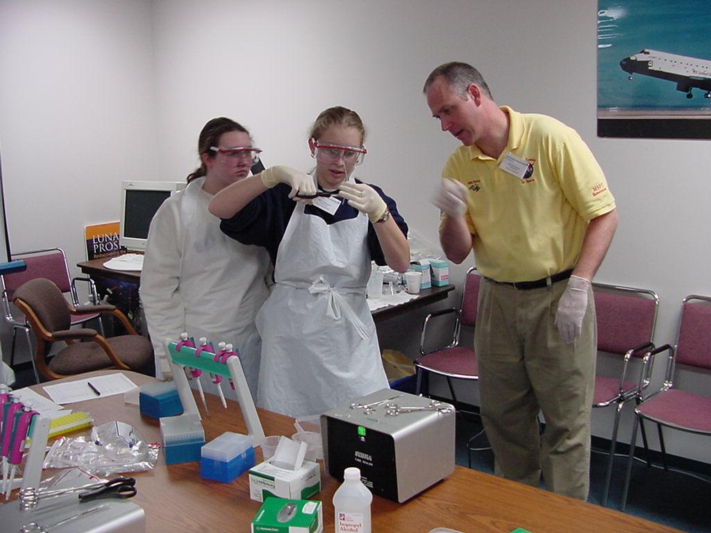 John Perkey helps a student with cutting a flight sample tube