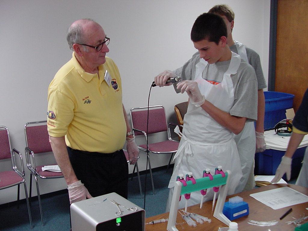 Jim Porter helps student with heat sealing a flight sample tube